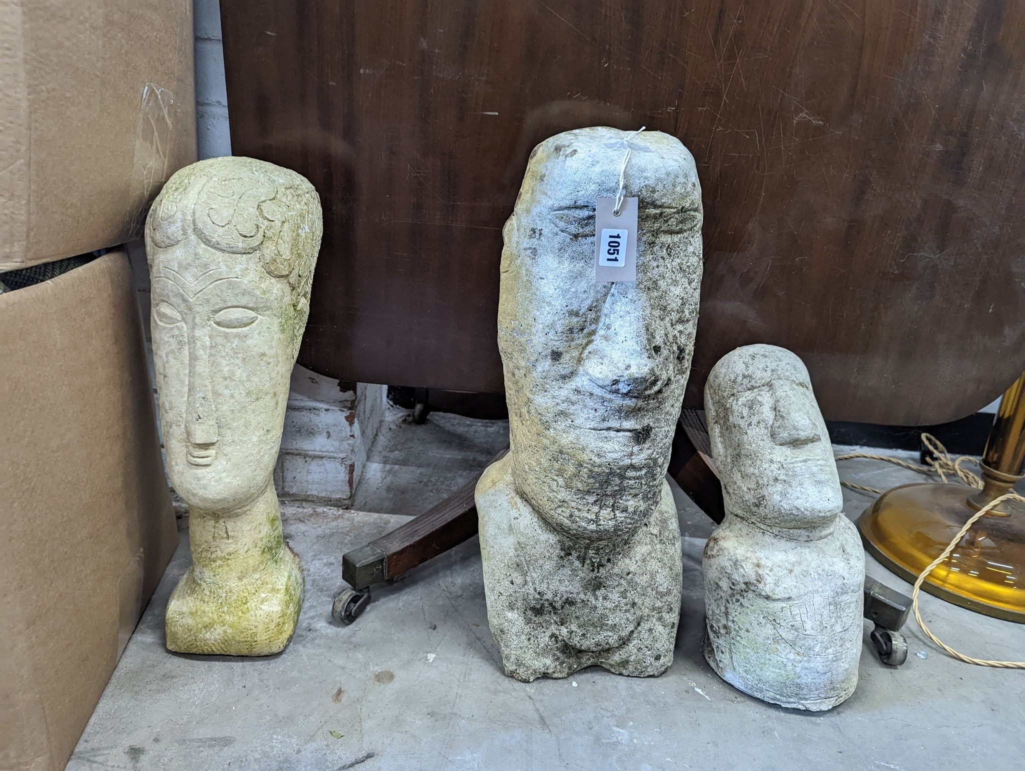 Three reconstituted stone Easter Island style garden ornaments, largest height 58cm